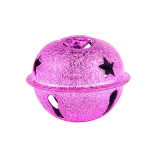 Macro detail van magenta matte metalen kerstbel met stervormig uitgesneden decoratie