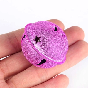 Detail van een grote roze glitterbel met steruitsnijdingen voor kerstdecoraties
