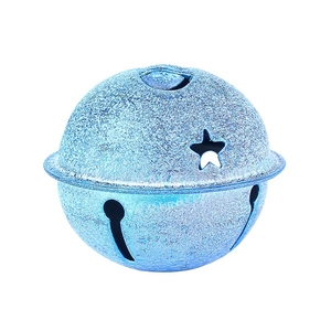 Detail van blauwe matte kerstbel met glitters en steruitsparingen op een witte basis