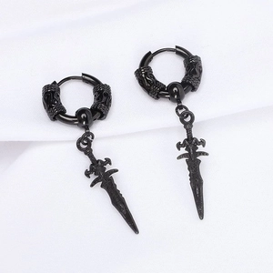 Macro shot of black gothic sword drop earrings with hoop on textured white background