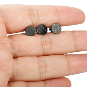 Detailansicht von drei schwarzen Edelstahl-Ohrsteckern in glatten, carbon und mattem Design