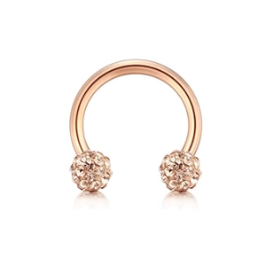 Detail of rose gold horseshoe ring featuring two spherical ends set with sparkling crystals