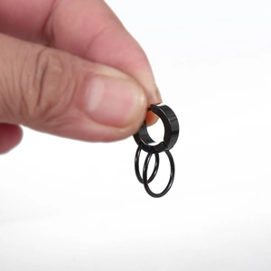 Minimalist black titanium steel double ring hoop earrings held to show scale on white base