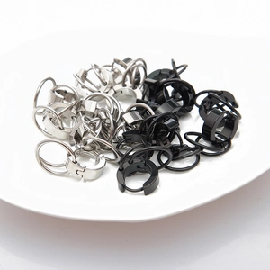 Polished black and silver stainless steel double hoop earrings on white ceramic base
