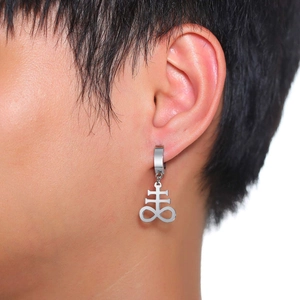 Close-up of a silver Leviathan Cross charm earring worn on a male ear lobe