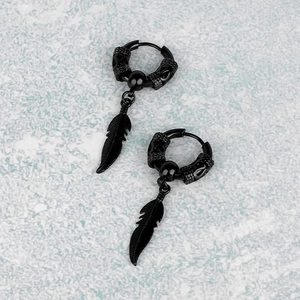 Punk black feather drop earrings with engraved hoop design on marble background