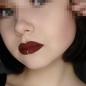 Close-up of a trendy gold C-shaped clip-on lip ring jewelry for women's facial piercing