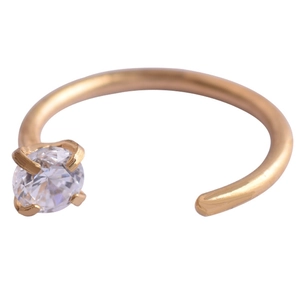 Macro shot of gold C-shaped stainless steel nose ring with four-prong set cubic zirconia