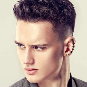 Set of black round stud earrings for men and women in various sizes on the ear