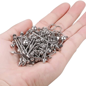 Bulk set of stainless steel body piercing jewelry with silver balls and spikes in hand