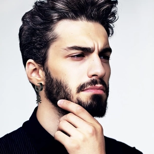 Dettaglio di un orecchino a teschio punk nero sull'orecchio di un modello uomo