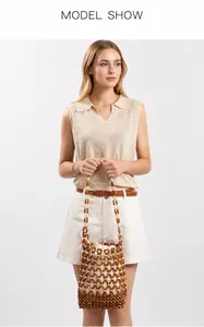 Dettaglio borsa di perle in legno marrone scuro con sacchetto interno bianco a coulisse