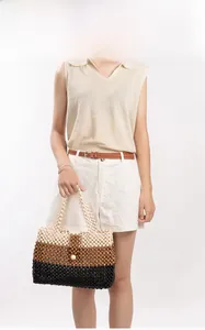 Detailed view of handmade tricolor beaded tote bag worn by a model against white background