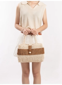 Detail of a handmade beaded tote bag with contrasting wood beads in a woven pattern
