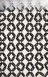 Close-up of black wooden bead weaving with white spheres and intricate mesh pattern
