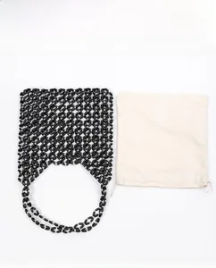 Detail of black handcrafted beaded shoulder bag with white inner drawstring liner pouch