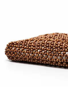 Detail of dark wood beads and manual weaving craftsmanship on the woven beach handbag