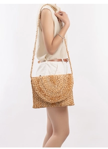 Détail d'un sac bandoulière en jute tressé main avec texture fibreuse sur un modèle