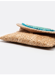 Detail of bohemian jute envelope clutch with turquoise fringe and woven texture