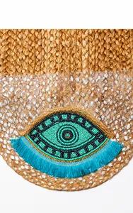 Detail der Jutetasche mit Evil-Eye-Perlenstickerei und blauen Fransen-Quasten