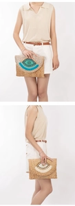 Close-up of handmade jute envelope clutch with evil eye beadwork and tassel fringe