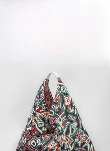 Macro detail of geometric dumpling bag with colorful graffiti jacquard patterns and leather straps