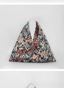 Detail of bohemian triangle tote bag with colorful graffiti print and white handle