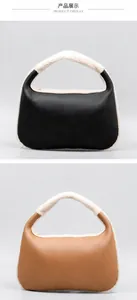 Detail of faux leather dumpling bag with soft white plush trim and top handle in black and brown