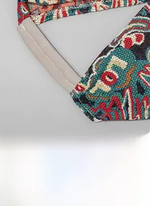 Detail of bohemian triangle bag showing woven ethnic pattern and leather stitching