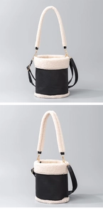 Detail view of contrast faux fur and black leather bucket bag with top handle and strap