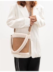 Detail view of brown PU leather bucket bag with cream faux fur trim on model