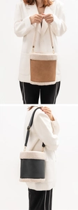Detail of faux leather bucket bag with fleece trim and adjustable shoulder strap