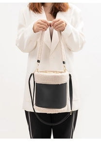 Detail of faux leather bucket bag with plush fleece trim and drawstring closure