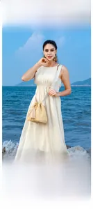 Close-up of beige straw bucket bag with tassels and ethnic patterned strap by the sea