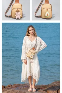 Dettaglio borsa a tracolla in paglia con cinturino colorato boho e ciondoli in peluche