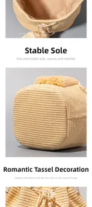 Detail view of woven straw bucket bag showing flat base, fabric lining, and tassel trim