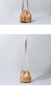Detail of woven straw bucket bag with tassel accent and geometric pattern shoulder strap