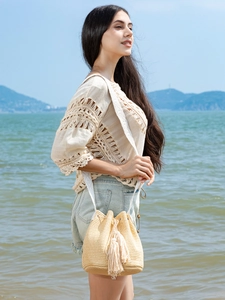 Straw bucket bag with fringe and ethnic embroidered strap for beach vacations