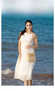 Detail view of a handmade white wooden bead crossbody bag for beach vacation style