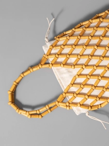 Handmade yellow wooden bead woven handbag with cream canvas drawstring inner bag