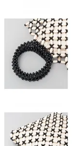 Close-up of handmade wooden bead handbag with thick black round handles and woven texture
