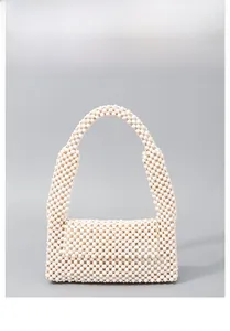 Close-up detail of a handmade beaded handbag featuring smooth creamy white wooden beads