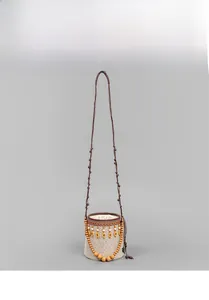 Detail of hand-woven straw bucket bag featuring geometric patterns and wooden beads