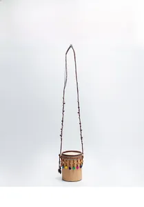 Détail d'un sac bandoulière en paille avec motifs ethniques et glands en perles colorées