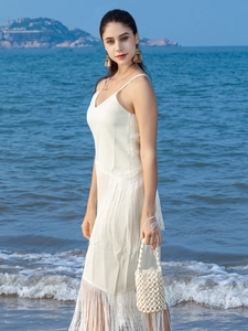 White bohemian fringe mini dress with wooden bead handbag for a stylish beach vacation look