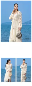 Detail of bohemian white lace crochet dress with fringe tassels for beach vacation