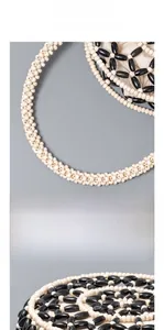 Detailed close-up of circular wooden handle and black and white woven bead craftsmanship