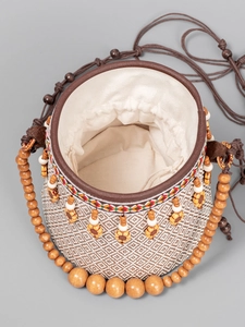 Ethnic woven straw bucket bag with wooden bead handle and diamond pattern for beach travel