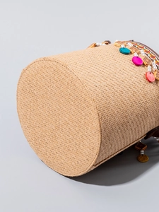 Handwoven straw bucket bag with colorful charms and beaded details for beach vacation