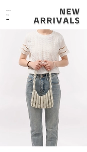 Detail of a handmade white pearl beaded bag with silver metal accents and round handle